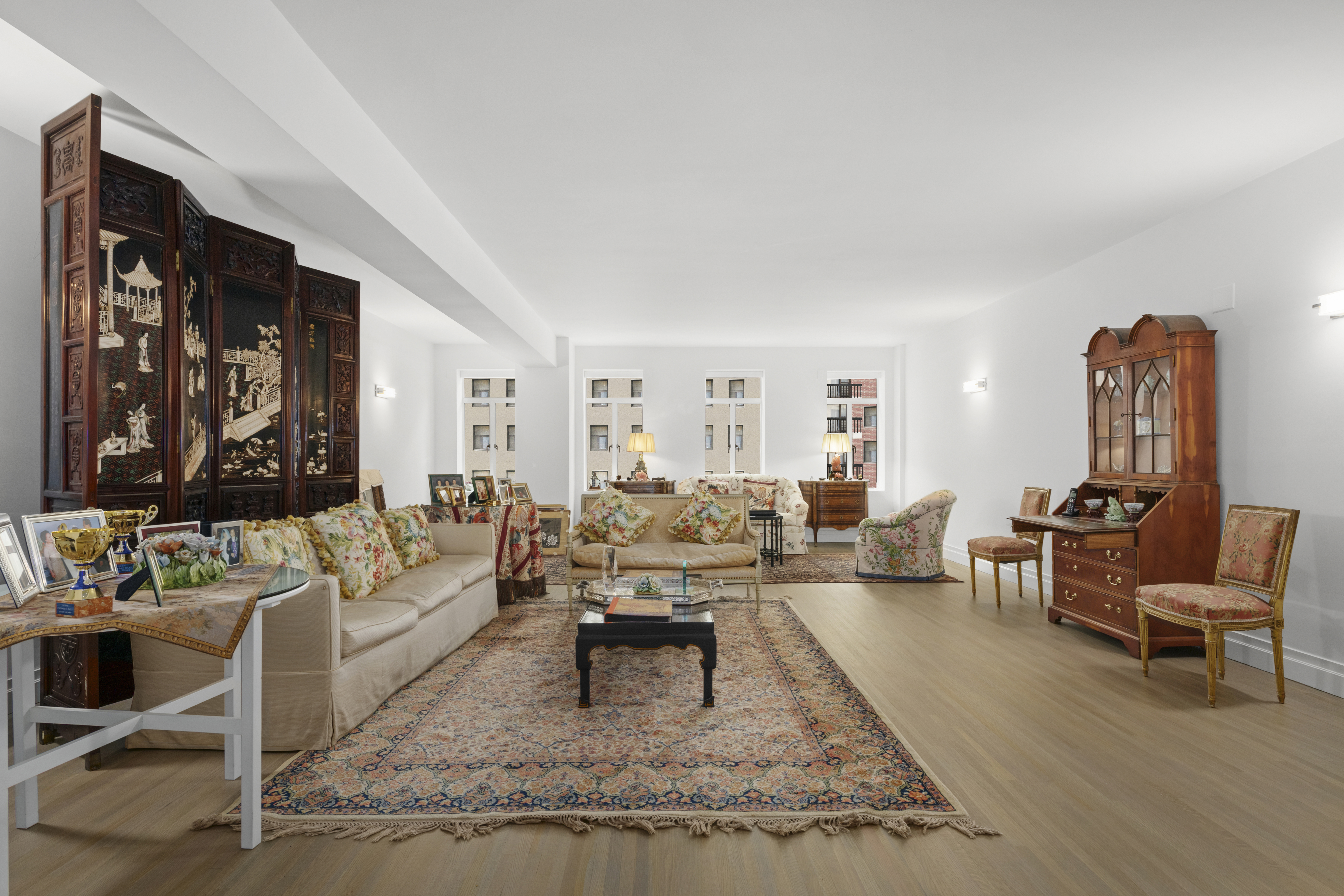 a living room with furniture couches and a dining table with wooden floor