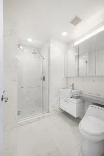 a bathroom with a double vanity sink toilet and shower