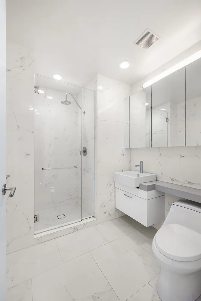 a bathroom with a double vanity sink toilet and shower