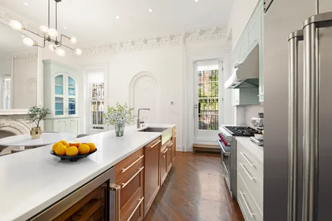 a kitchen with sink a stove and cabinets