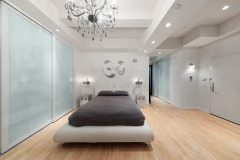a bedroom with a large bed and a chandelier