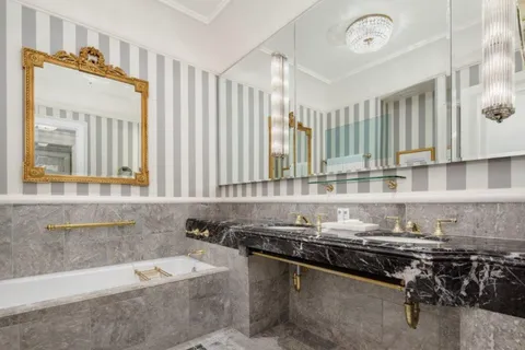 a bathroom with a granite countertop sink a mirror and a bathtub