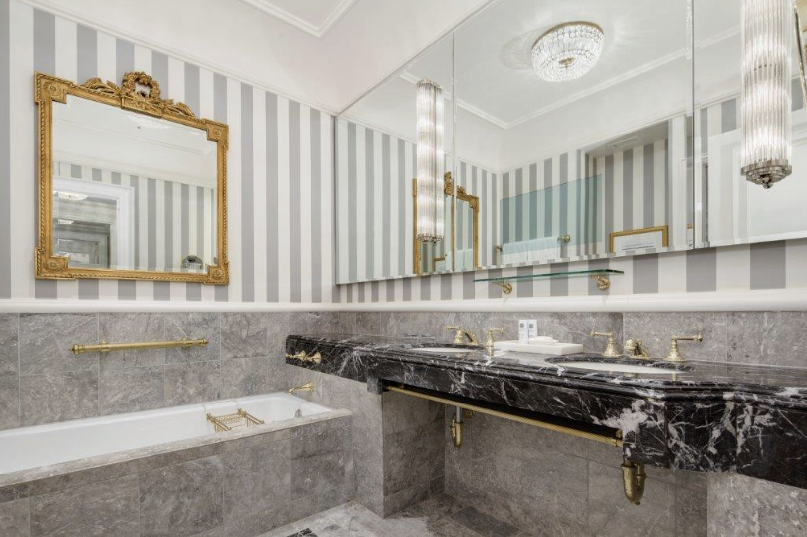 2 East 55th Street, Unit 936W39 Manhattan, NY 10022 - Photo 6 of 11 a bathroom with a granite countertop sink a mirror and a bathtub