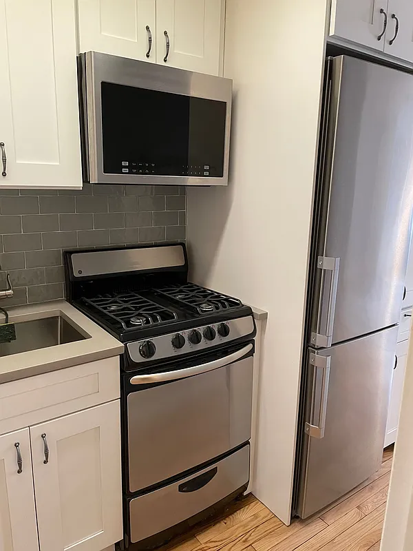 433 West 34th Street, Unit 7B Manhattan, NY 10001 - Photo 7 of 13 a stove top oven sitting inside of a kitchen