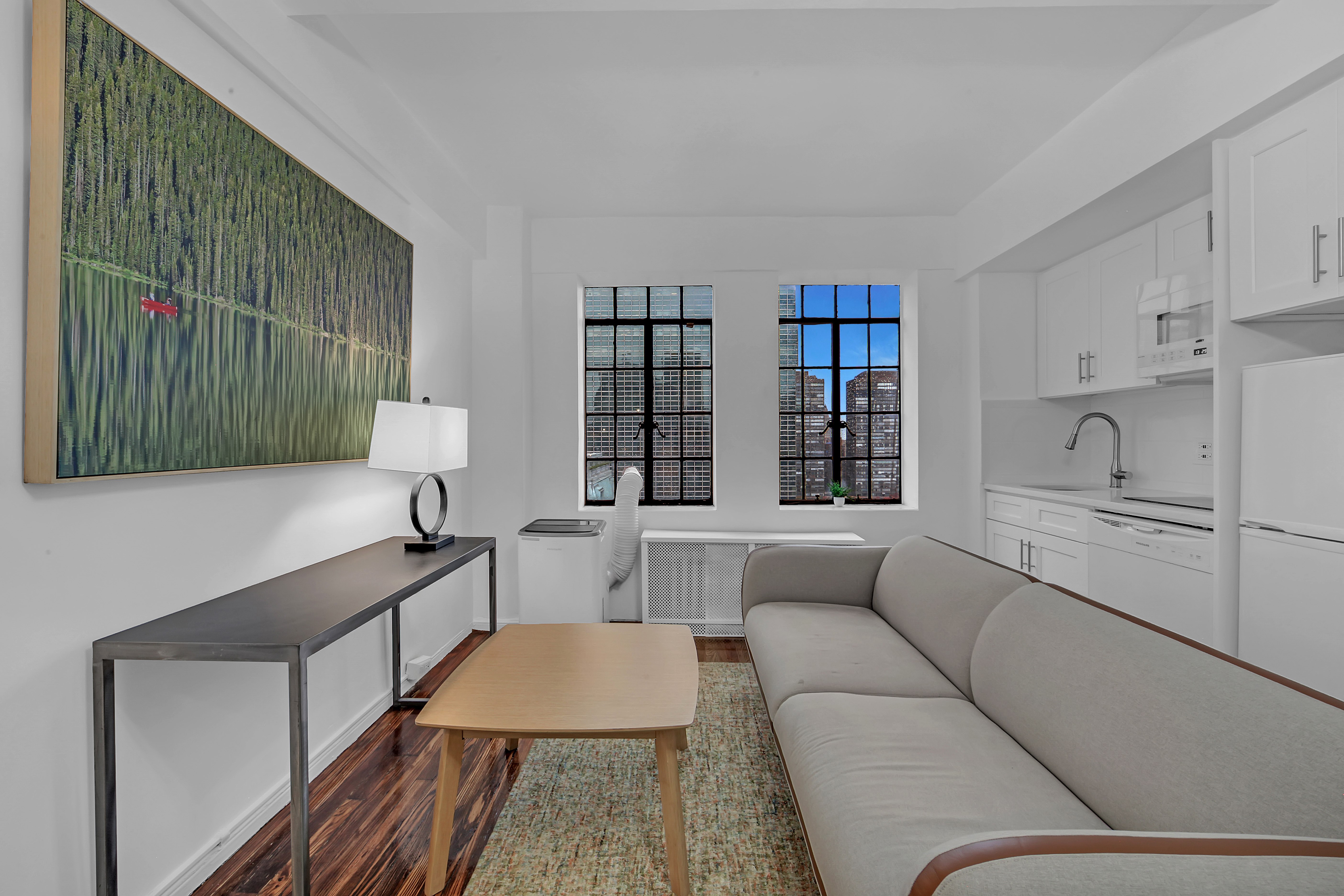 45 Tudor City Place, Unit 1902 Manhattan, NY 10017 - Photo 8 of 19 a living room with furniture and a window