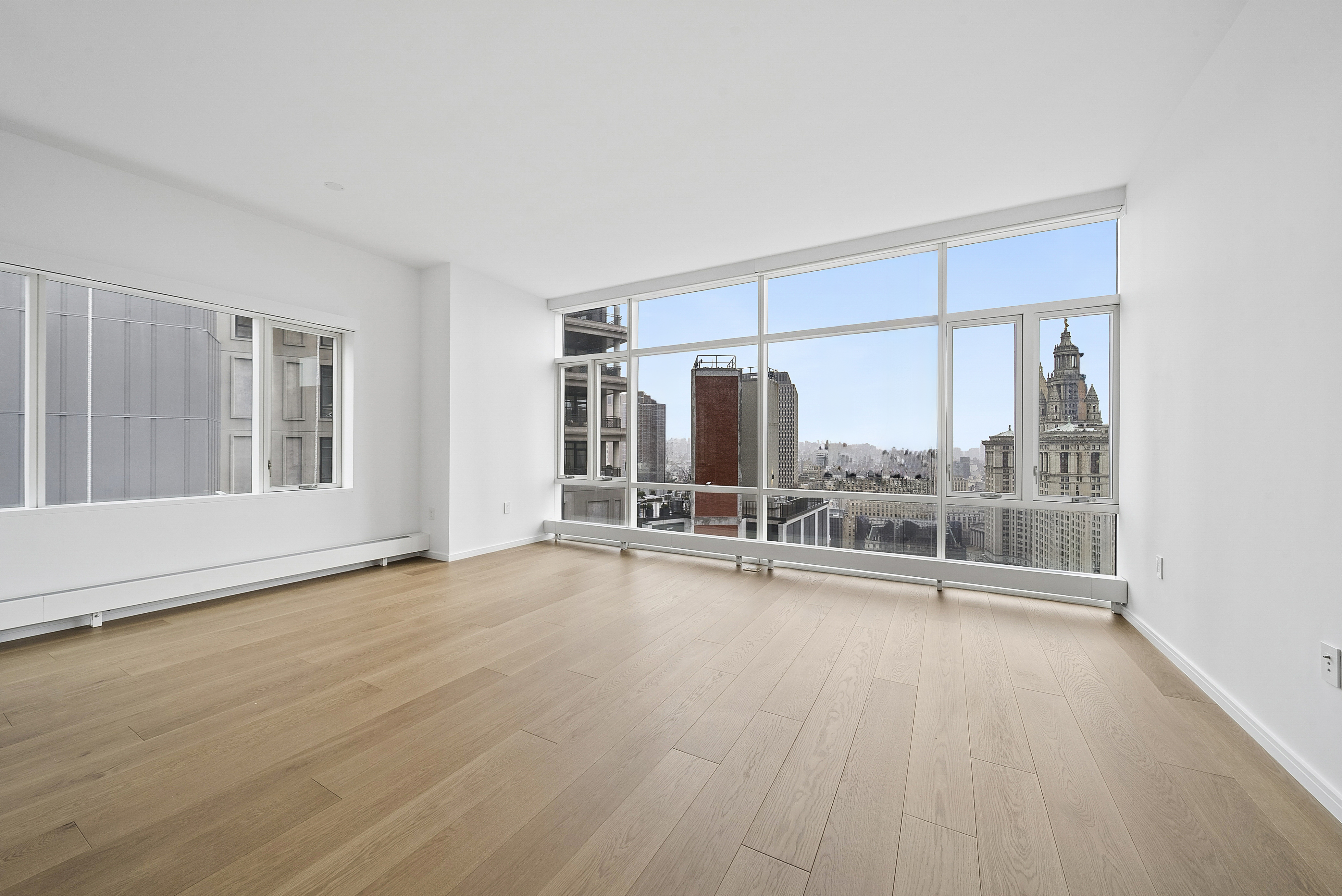 5 Beekman Street, Unit 30A Manhattan, NY 10038 - Photo 4 of 15 an empty room with wooden floor and windows