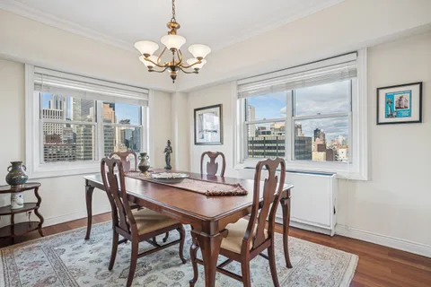 a dining room with furniture a chandelier and wooden floor