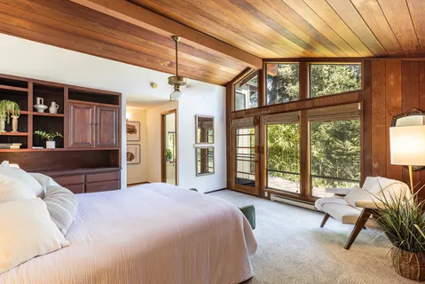 a spacious bedroom with a bed and a large window