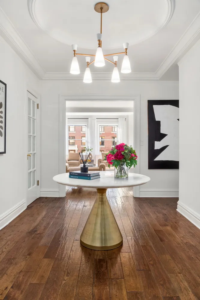 a view of a room with wooden floor and chandelier