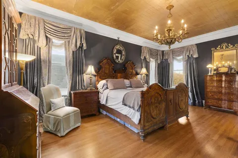 a spacious bedroom with a bed and a chandelier