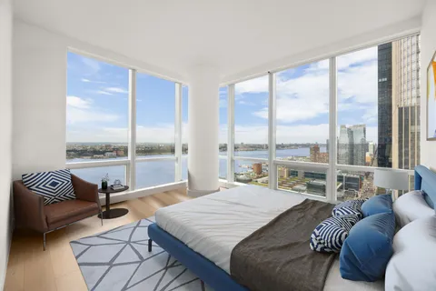 a bedroom with furniture and a large window