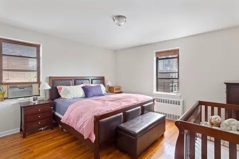 a spacious bedroom with a bed a dresser and a window