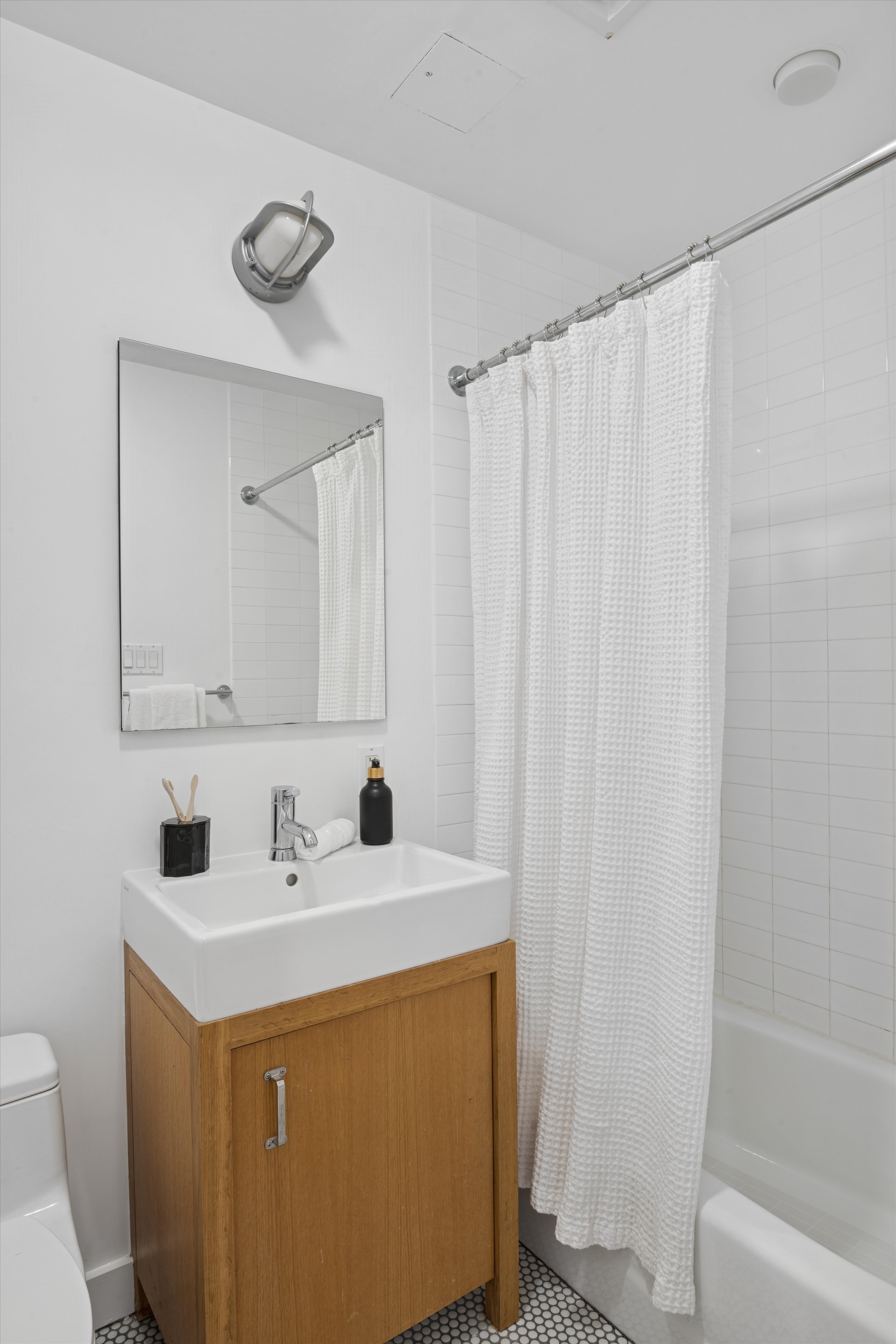 109 West 26th Street, Unit 9 Manhattan, NY 10001 - Photo 21 of 23 a bathroom with a sink a toilet and a mirror