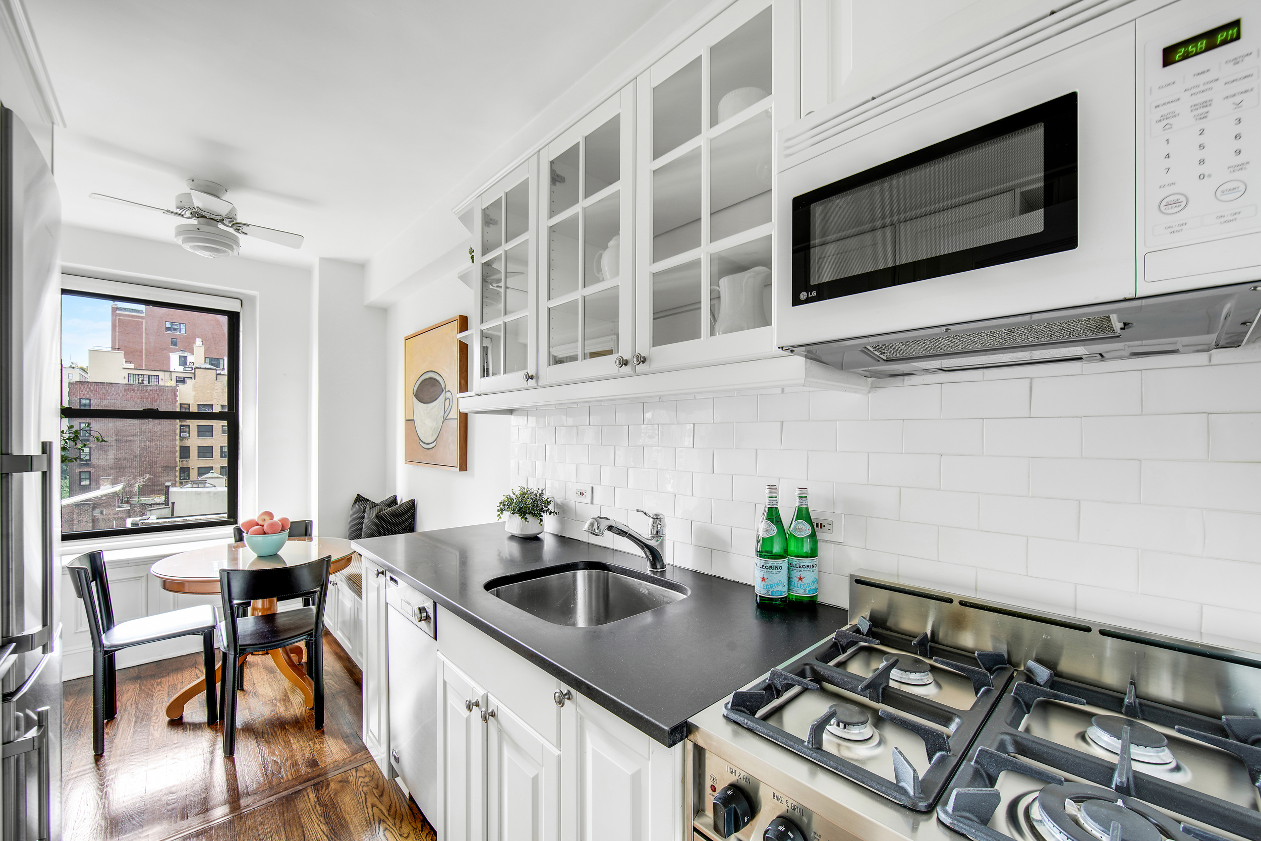 205 East 78th Street, Unit 9F Manhattan, NY 10075 - Photo 5 of 13 a kitchen with stainless steel appliances a stove a sink and a microwave