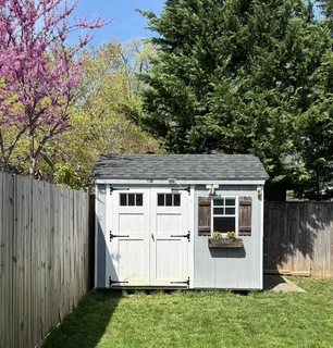a view of a house with backyard and a tree