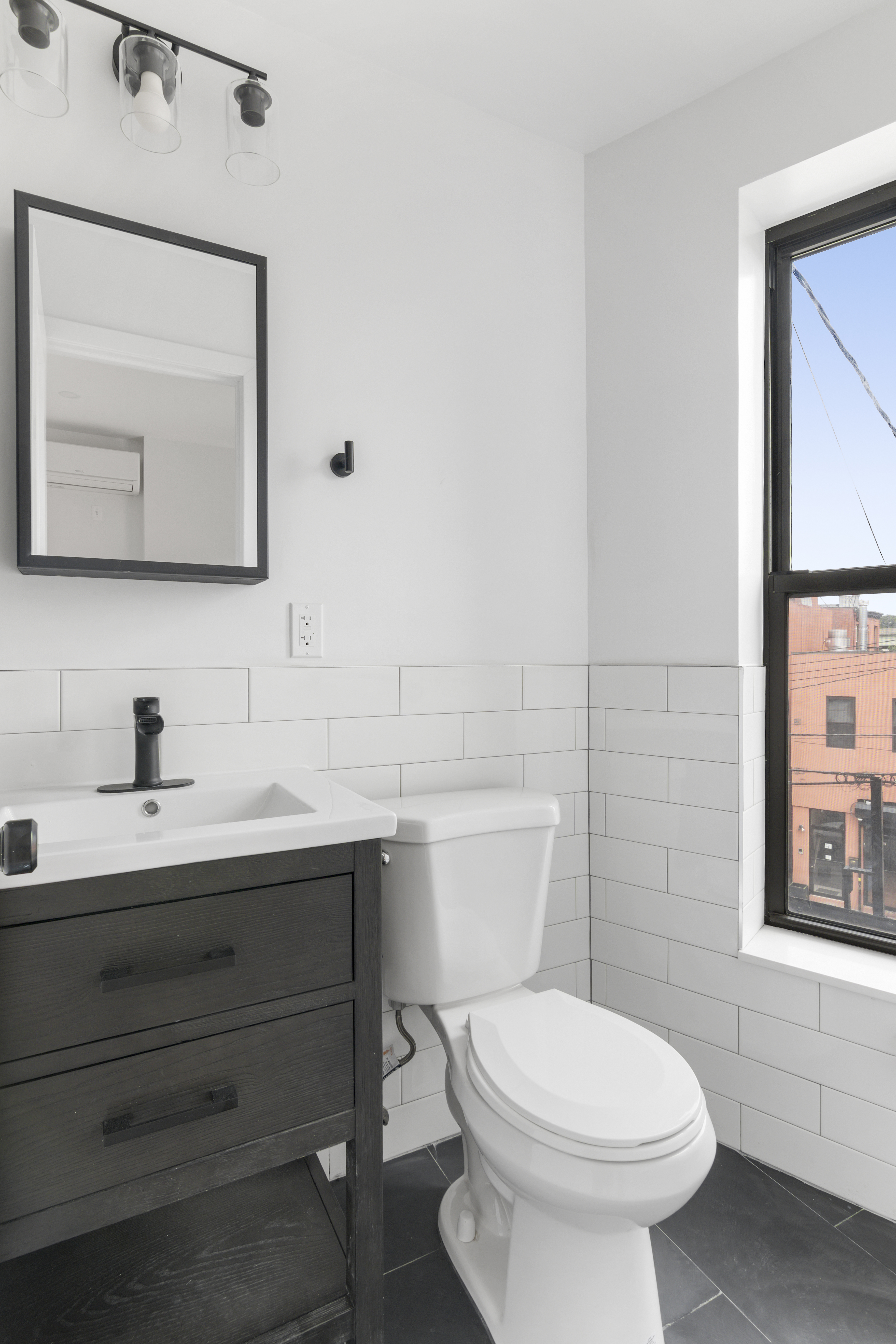 366 Columbia Street, Unit 3 Brooklyn, NY 11231 - Photo 4 of 11 a bathroom with a toilet a sink a mirror and a window