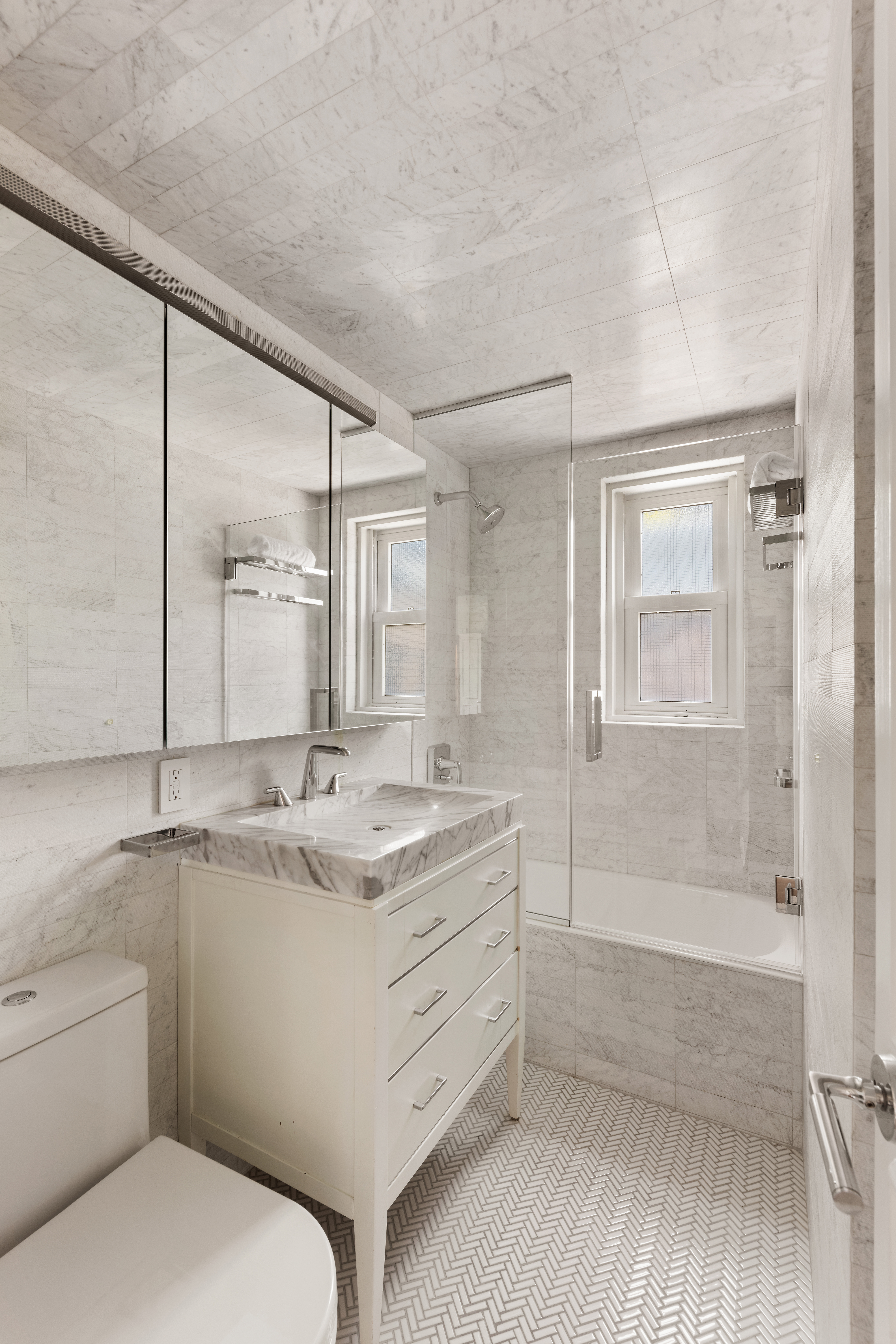 799 Park Avenue, Unit 17A Manhattan, NY 10021 - Photo 8 of 12 a bathroom with a granite countertop sink a toilet and shower