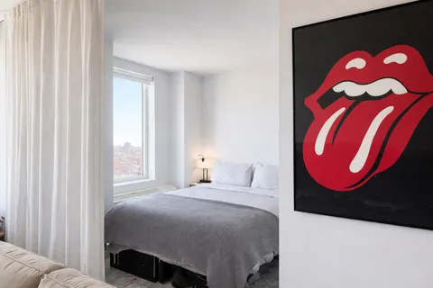 a bedroom with a bed and painting on the wall