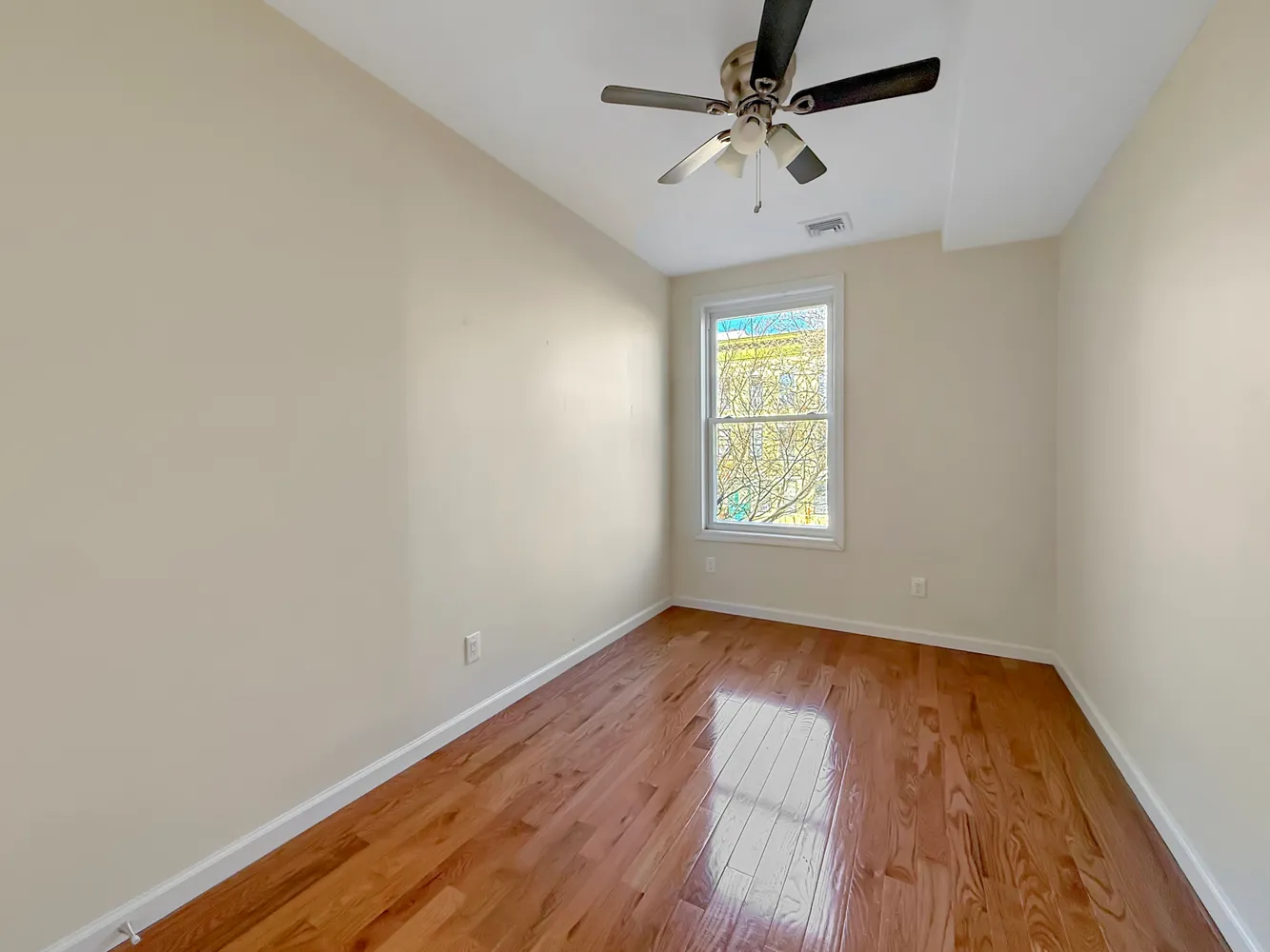 wooden floor in an empty room with a window