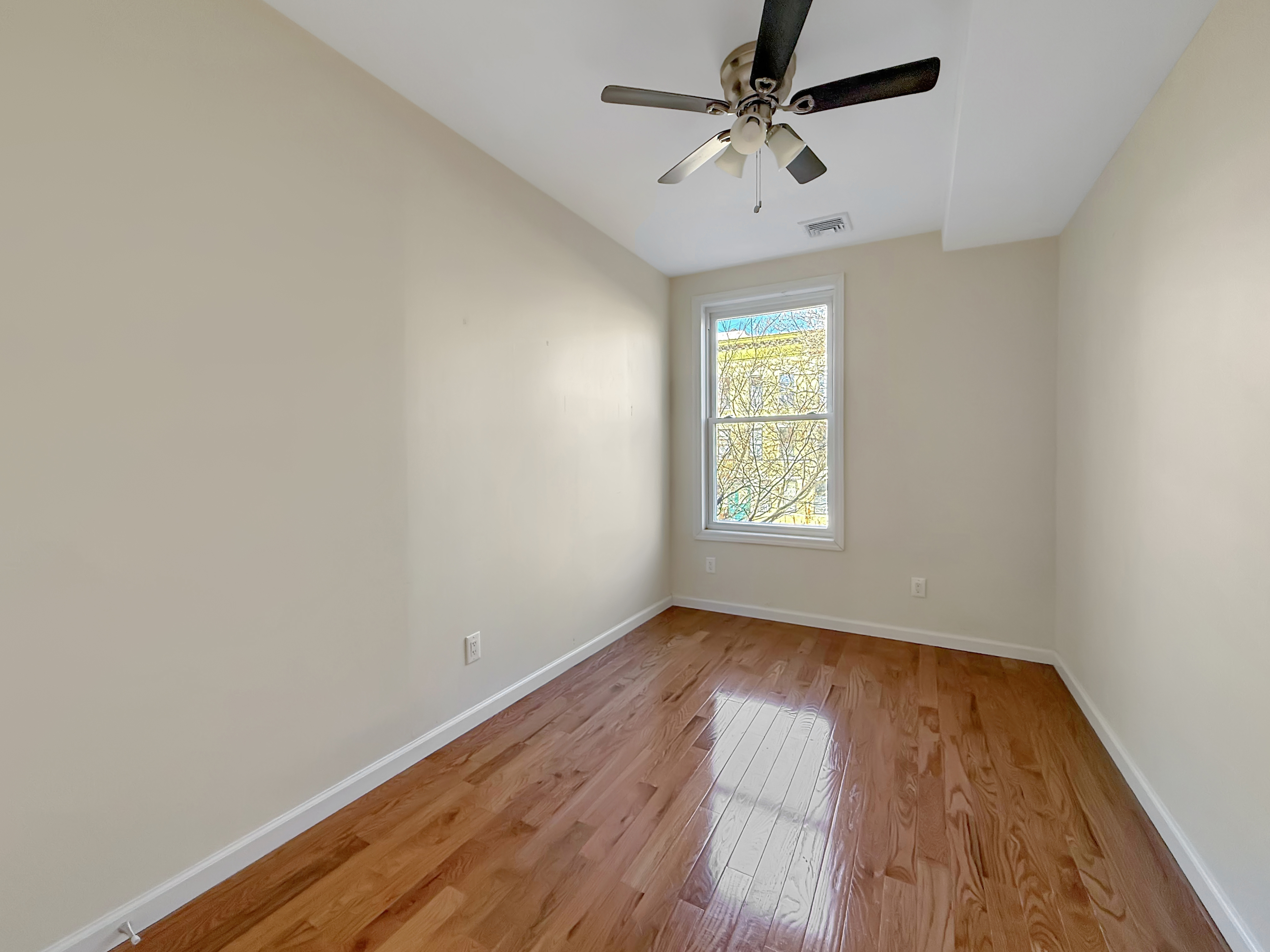 432 Chauncey Street, Unit 1 Brooklyn, NY 11233 - Photo 5 of 9 wooden floor in an empty room with a window