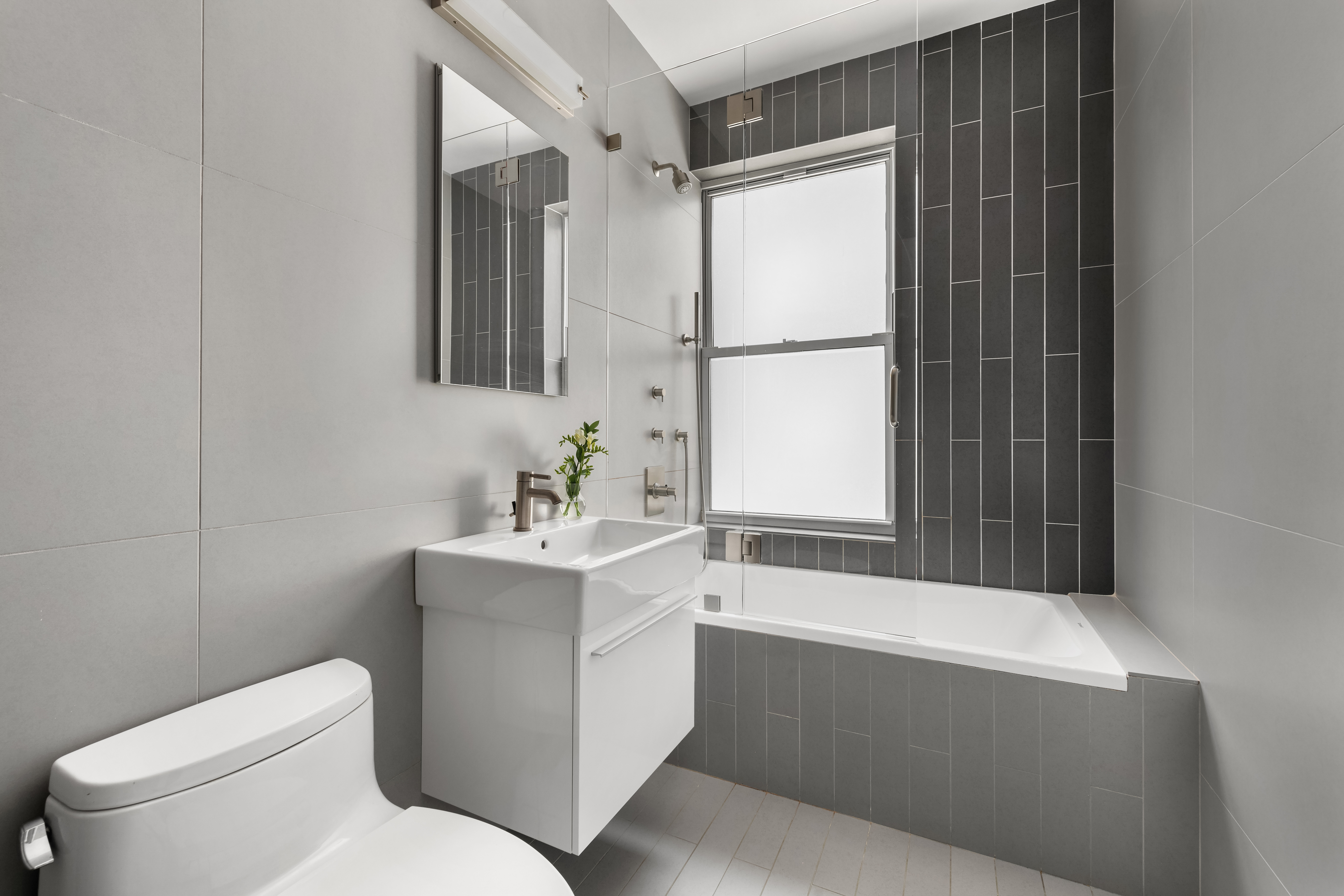 150 East 93rd Street, Unit 6AC Manhattan, NY 10128 - Photo 9 of 17 a bathroom with a sink toilet and mirror