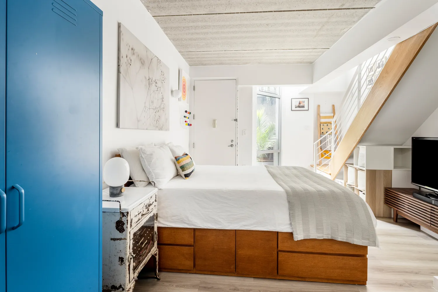 a bedroom with a bed and a flat tv screen