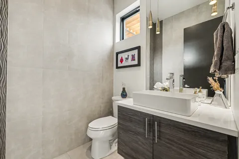 a bathroom with a sink vanity mirror and toilet