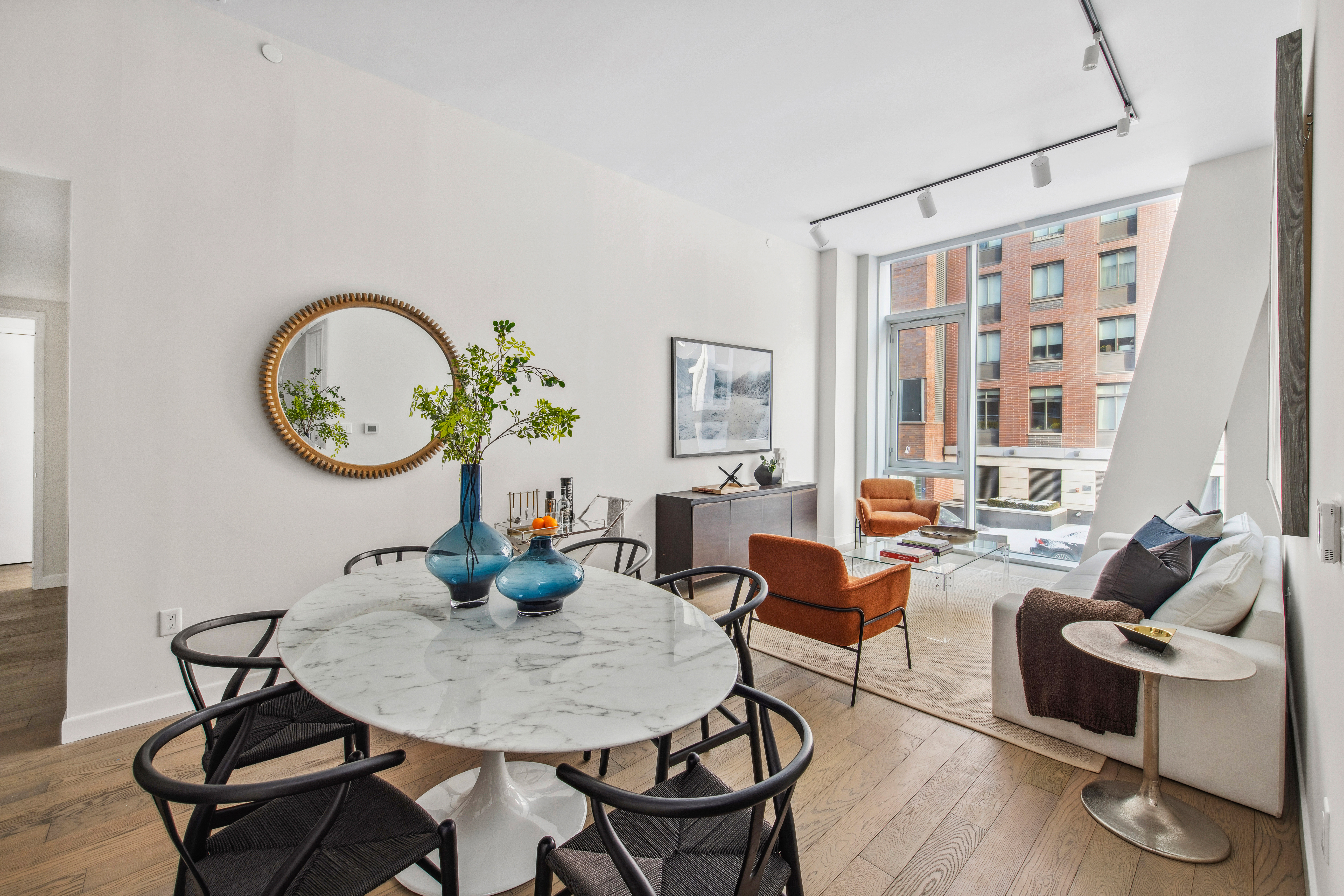 505-513 West 43rd Street, Unit 2B Manhattan, NY 10036 - Photo 2 of 18 a living room with fireplace furniture and a large window