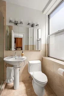a bathroom with a sink toilet and mirror
