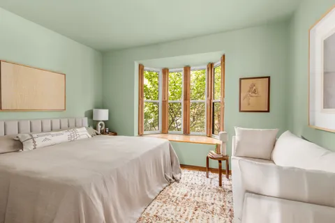 a bedroom with a large bed and a couch next to a window