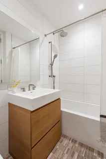 a bathroom with a sink mirror and a bathtub