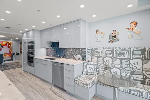 a large kitchen with stainless steel appliances granite countertop a large counter top and a sink
