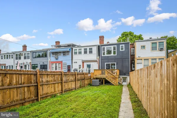 a view of a house with wooden deck and furniture