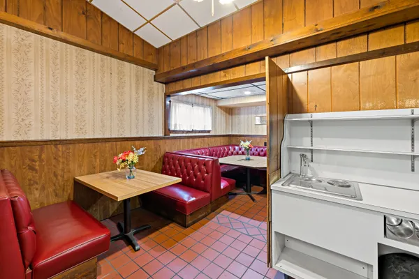 a kitchen with stainless steel appliances granite countertop a barbecue grill and couches with wooden floor