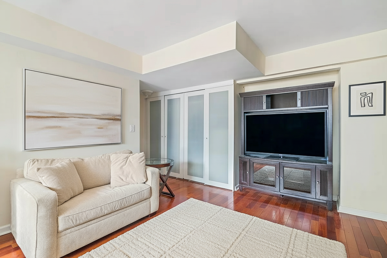 153 East 57th Street, Unit 17F Manhattan, NY 10022 - Photo 2 of 8 a living room with furniture and a flat screen tv