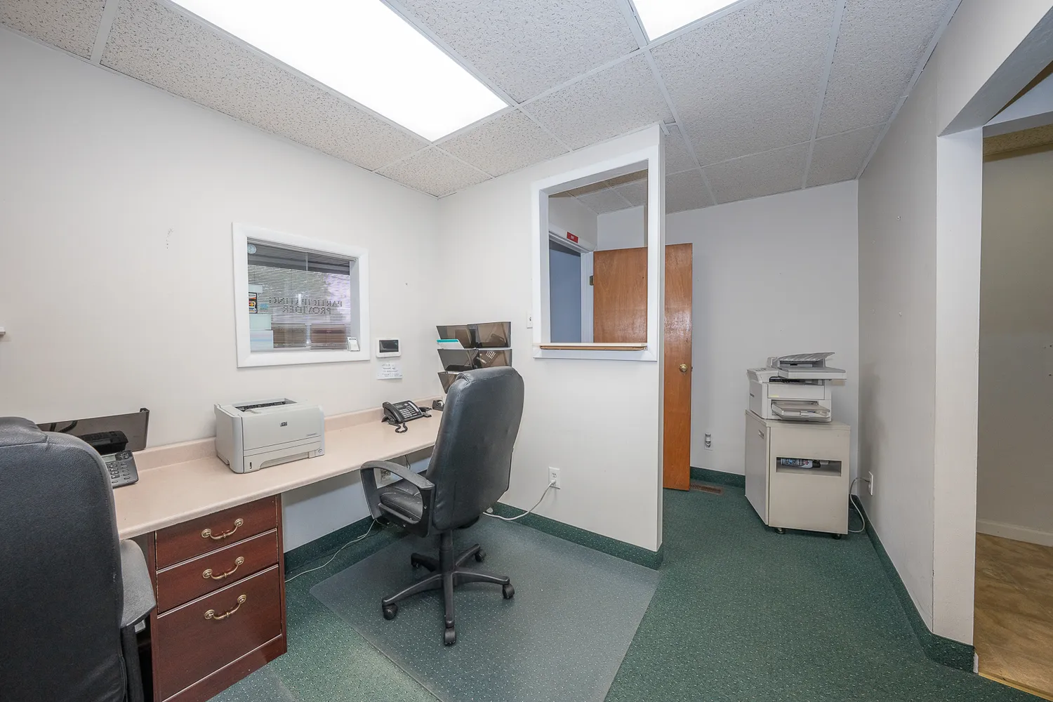 a view of a workspace with furniture and a window