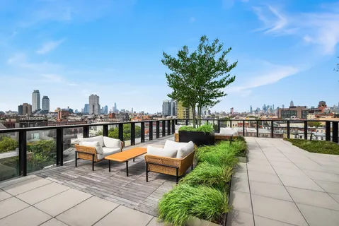 a view of a terrace with lawn chairs and iron fence