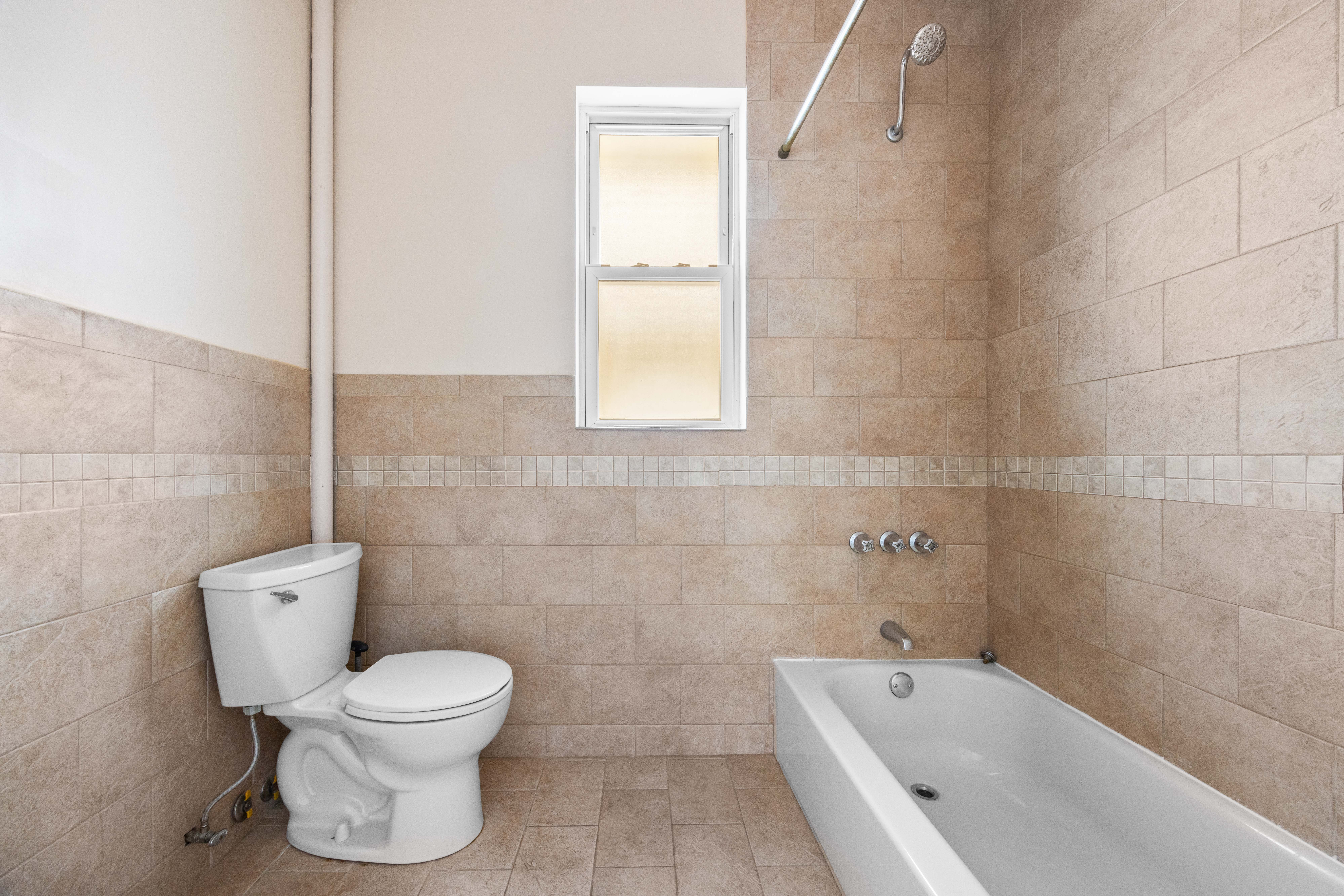 3712 Oceanic Avenue, Unit 2 Brooklyn, NY 11224 - Photo 9 of 14 a white toilet sitting next to a bathtub