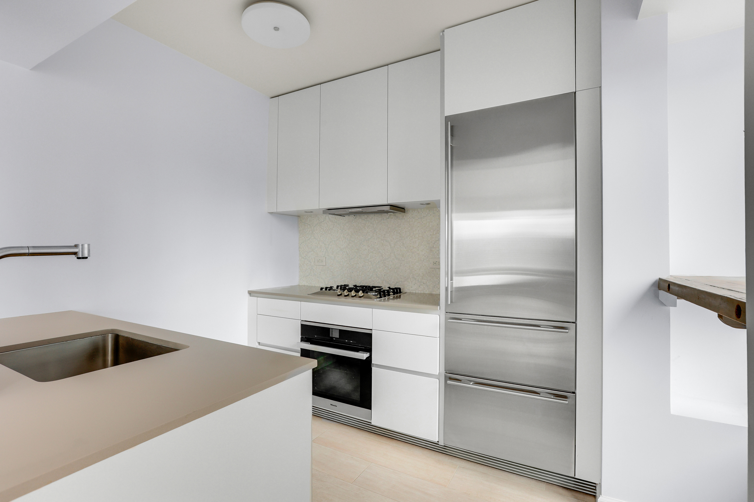 150 West 56th Street, Unit 3602 Manhattan, NY 10019 - Photo 3 of 12 a kitchen with a refrigerator and a sink