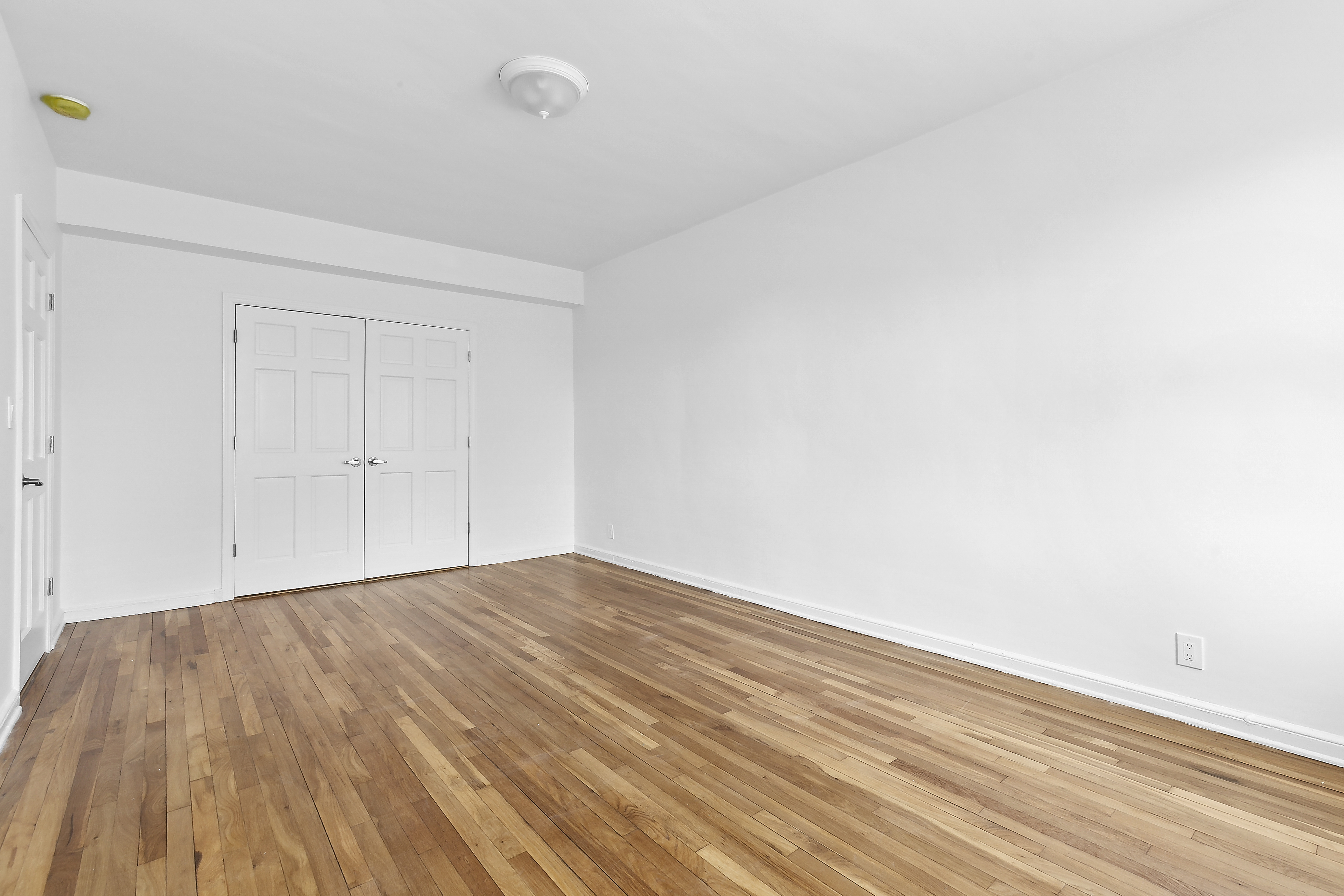 159-34 Riverside Drive West, Unit 5F90 Manhattan, NY 10032 - Photo 13 of 23 a view of empty room with wooden floor