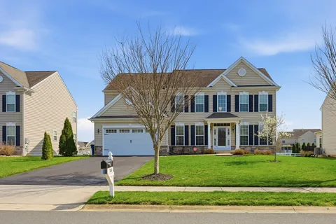 a front view of a house with a garden and plants