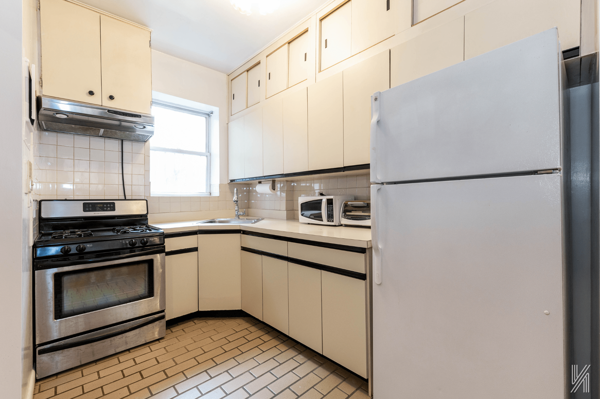 32-10 35th Street Queens, NY 11106 - Photo 5 of 29 a kitchen with a white cabinets and white appliances