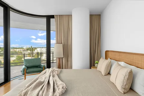 a bedroom with a bed and large window