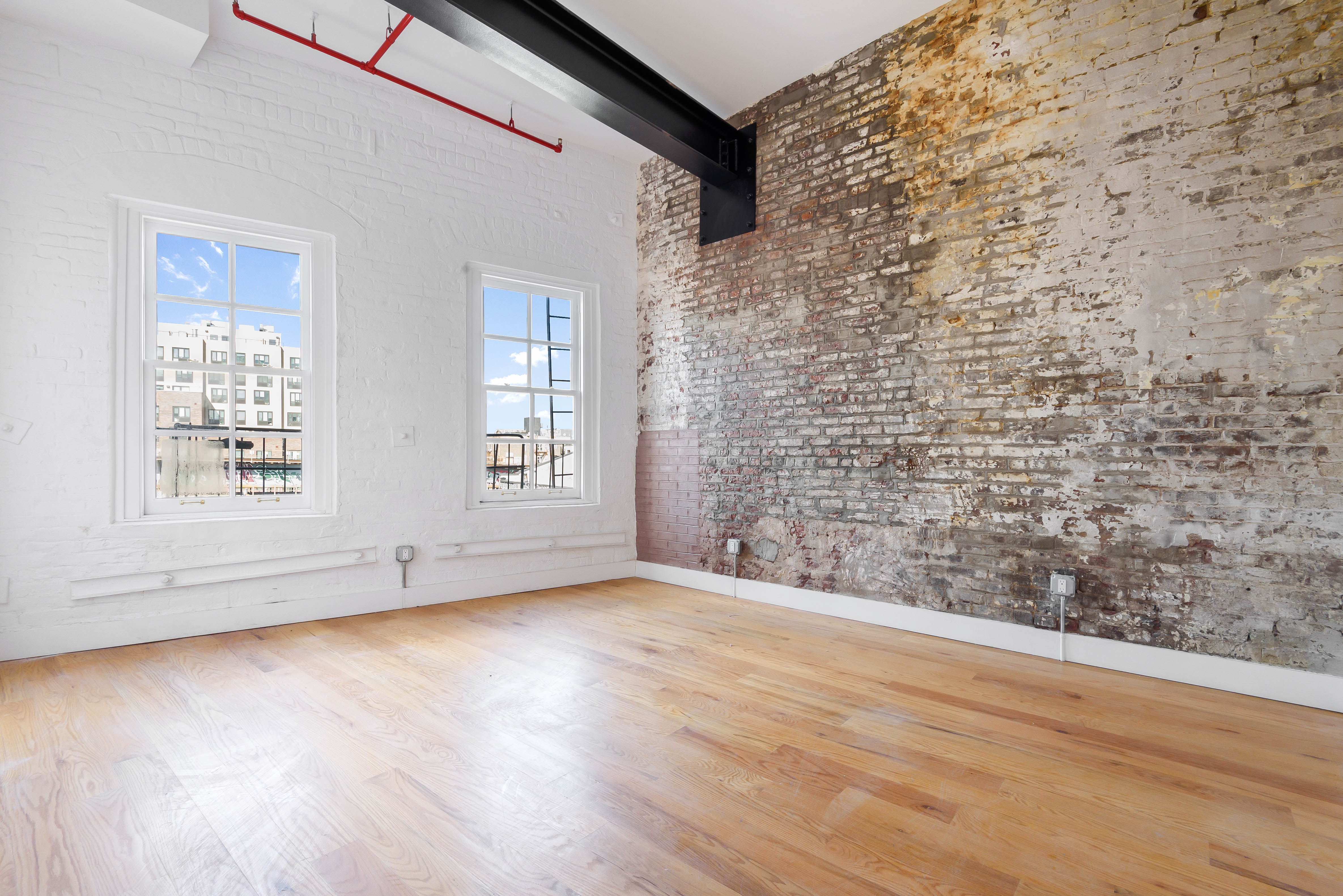 103 Broadway, Unit 4 Brooklyn, NY 11249 - Photo 4 of 7 a view of an empty room with wooden floor and a window
