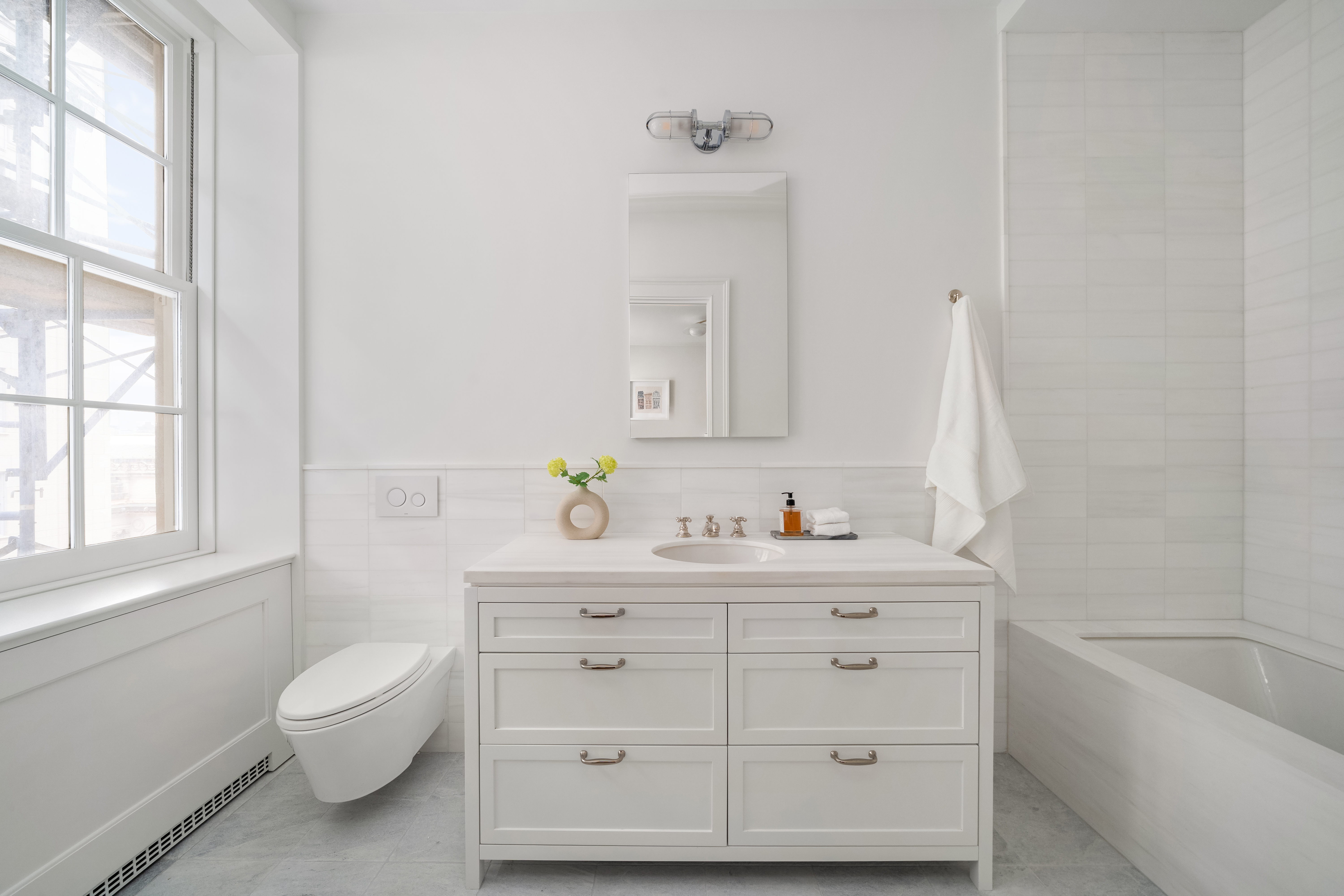 1020 5th Avenue, Unit 9 Manhattan, NY 10028 - Photo 24 of 27 a bathroom with a granite countertop toilet a sink a mirror and a window