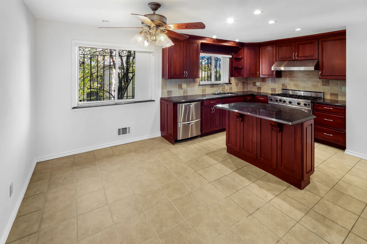 a kitchen with stainless steel appliances granite countertop a stove a sink dishwasher and a refrigerator