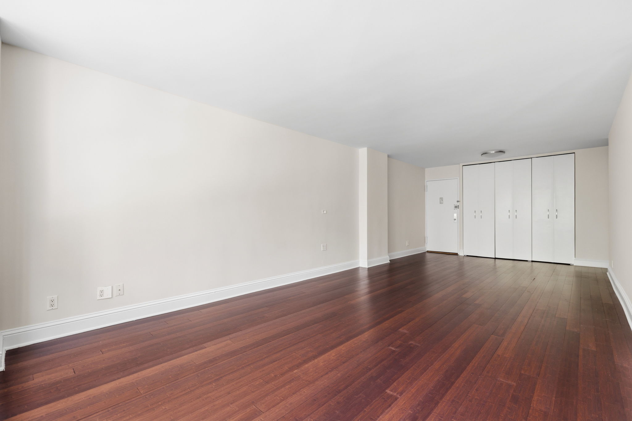 360 East 72nd Street, Unit A306 Manhattan, NY 10021 - Photo 15 of 17 a view of an empty room with wooden floor