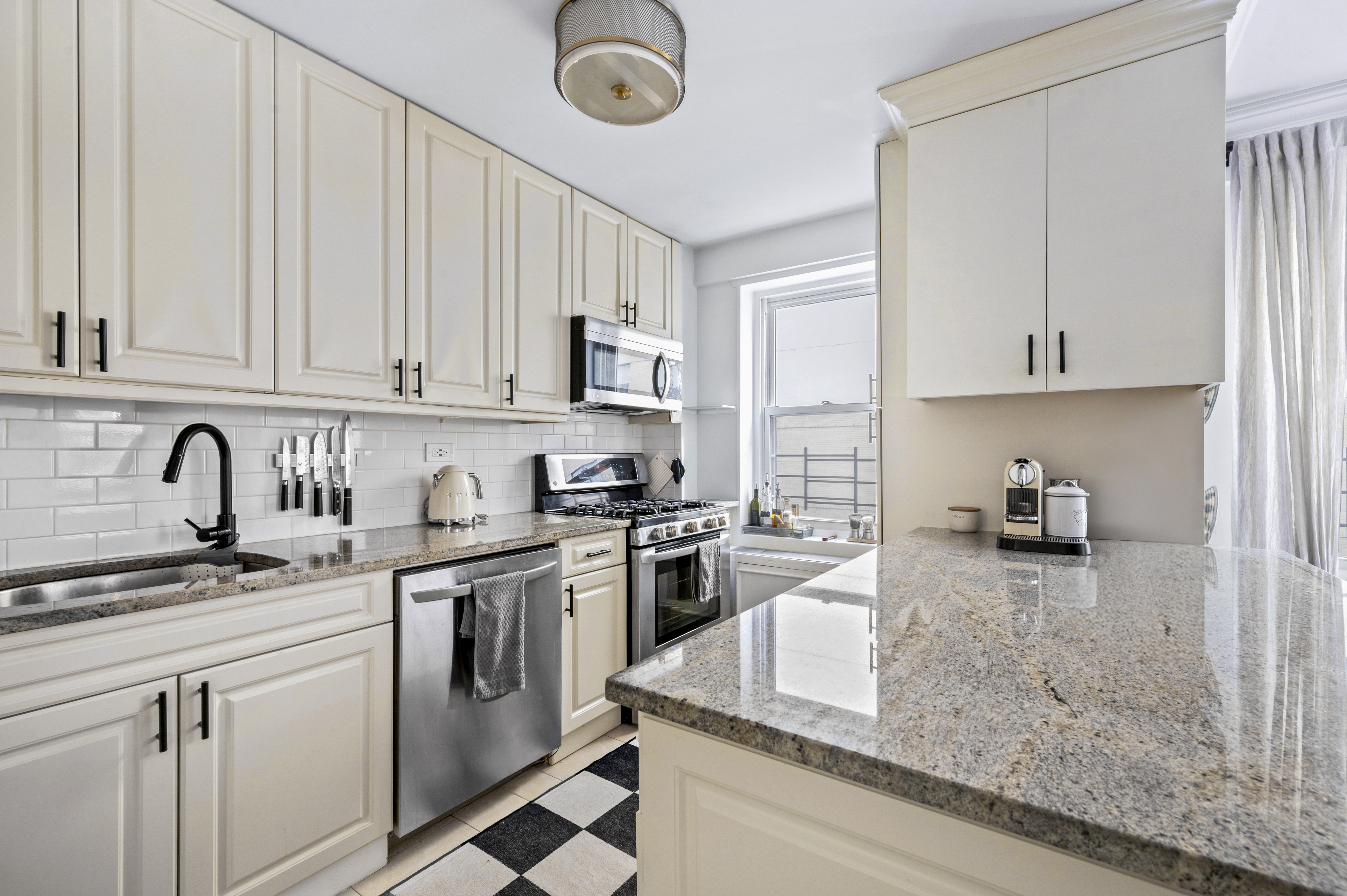 201 East 79th Street, Unit 6A Manhattan, NY 10075 - Photo 2 of 11 a kitchen with stainless steel appliances granite countertop a stove sink and cabinets