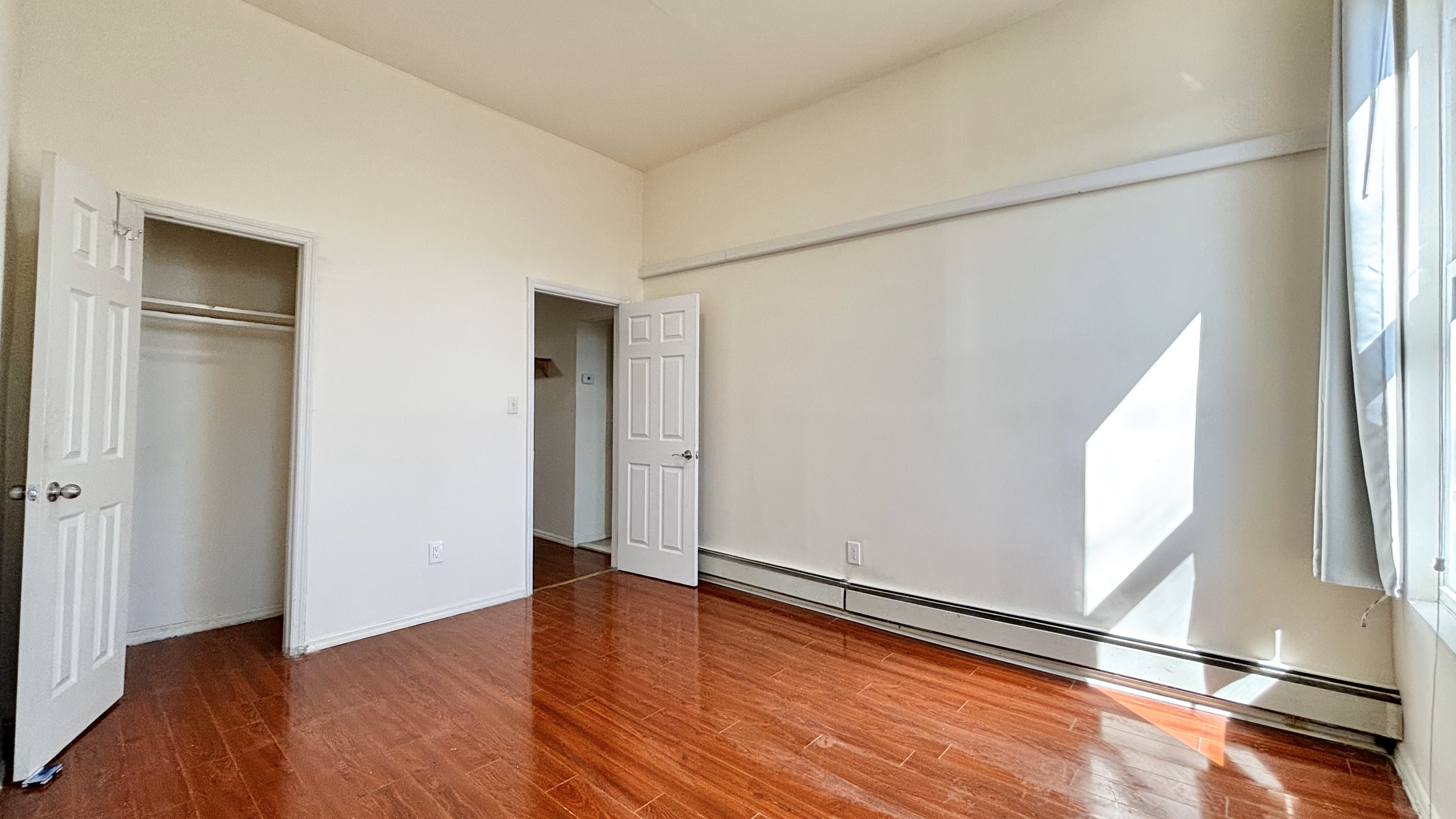 74 Himrod Street, Unit 2 Brooklyn, NY 11221 - Photo 8 of 16 an empty room with wooden floor and windows