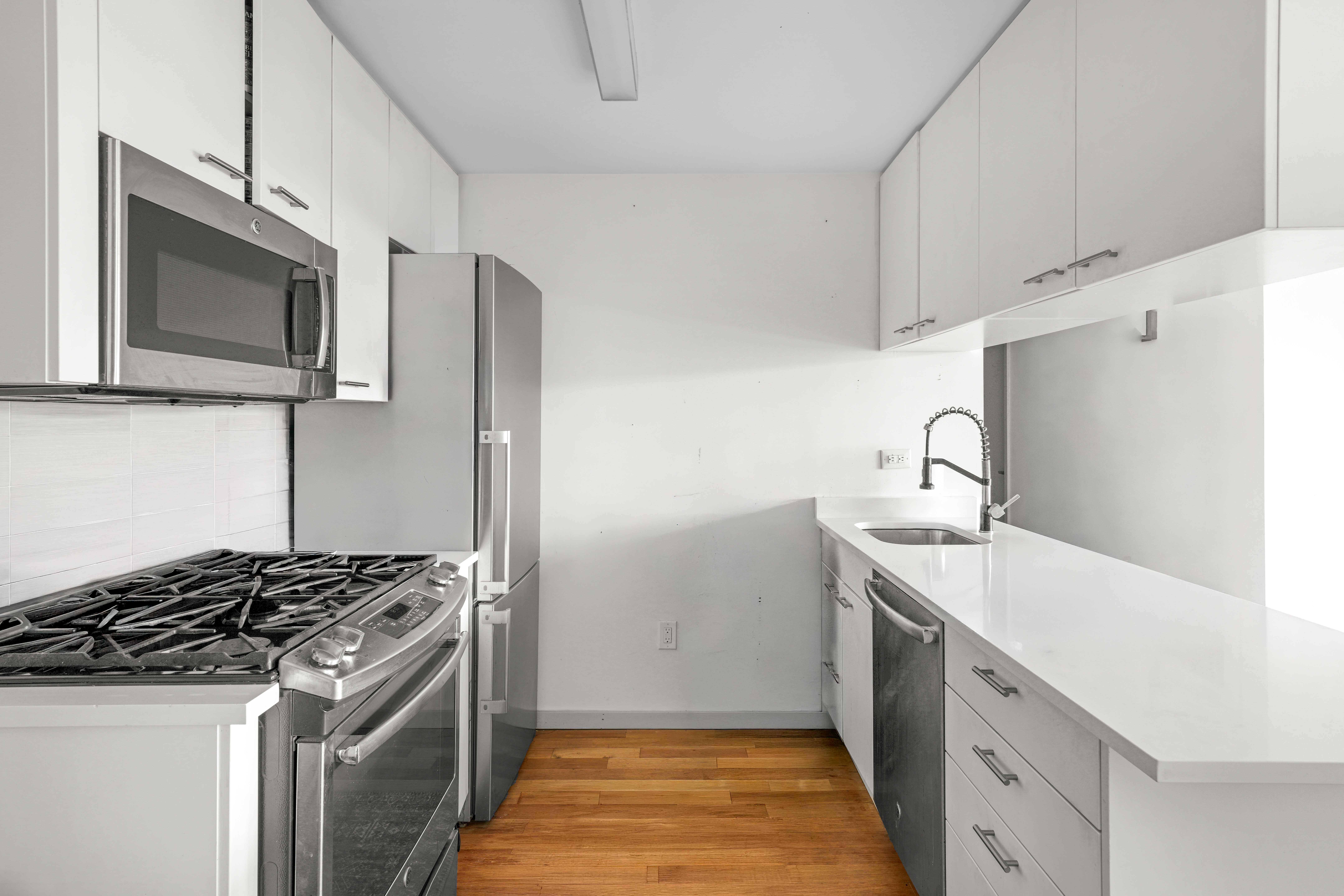 448 West 167th Street, Unit 3E Manhattan, NY 10032 - Photo 8 of 24 a kitchen with stainless steel appliances granite countertop a sink stove and refrigerator